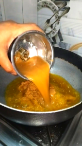 Adding freshly prepared masala paste into hot oil in a pan for Keema Kofta Curry