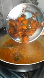 Adding fried keema koftas into hot masala gravy for Keema Kofta Curry