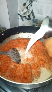 Carrots cooking with milk in a pan for Gajar Ka Halwa