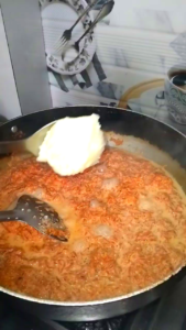 Adding desi ghee to Gajar Ka Halwa while cooking