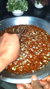 Cutting til chikki into pieces and letting it cool to set