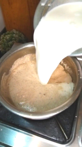Pouring milk into dry fruits paste for Ramzan Sehri Turri drink