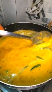 kadhi pakora cooking process simmering kadhi curry in pan