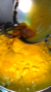 final tadka on kadhi pakora curry adding spices tempered oil mustard seeds