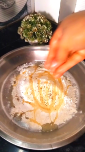 Adding salt, oil, ajwain and suji to maida for namak para recipe