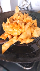 Removing crispy fried namak para from hot oil