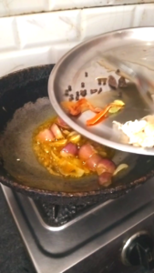 Adding whole spices to softened onions for Dhaba Style Matar Paneer Recipe