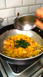 Adding Green Chilies to Softened Onions for Bhindi Recipe